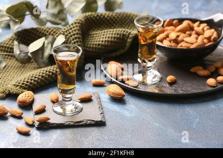 Composition avec verres de liqueur d'amande et noix de couleur arrière-plan Banque D'Images