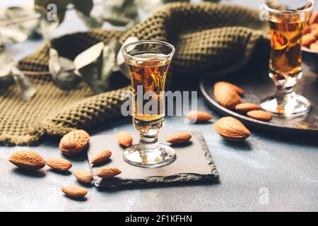 Composition avec verres de liqueur d'amande et noix de couleur arrière-plan Banque D'Images