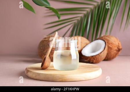 Pot d'huile de coco et cuillère sur fond de couleur Banque D'Images