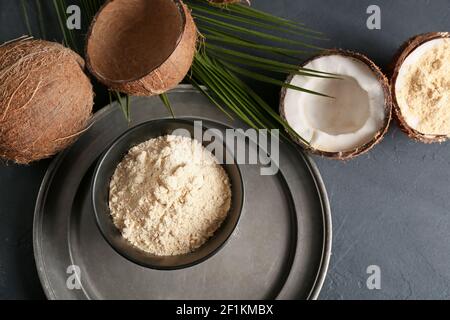 Bol avec farine de noix de coco sur fond sombre Banque D'Images