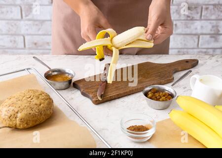 Femme cuisant des biscuits à la banane dans la cuisine Banque D'Images