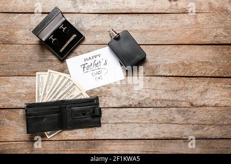 Composition pour la fête des pères avec portefeuille, parfum, boutons de manchette et carte de vœux sur fond de bois Banque D'Images