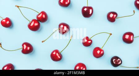 Motif lumineux de cerises mûres sur fond bleu. Banque D'Images