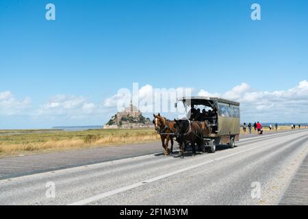 Cheval et calèche transportant des touristes au célèbre Mont Saint-Michel Dans le nord de la France Banque D'Images