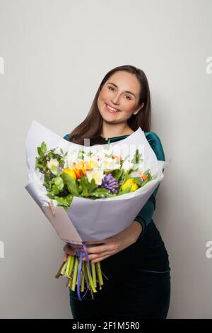 Belle femme avec des fleurs sur fond blanc Banque D'Images