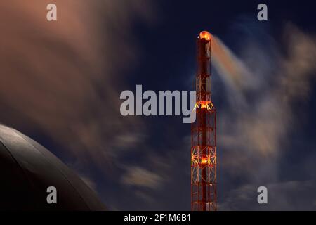 Signalé par des lumières rouges, un conduit de fumée sélectif et sphérique détenteur d'une usine pétrochimique de nuit, sombre et spectaculaire, ciel long prise de vue en temps réel Banque D'Images