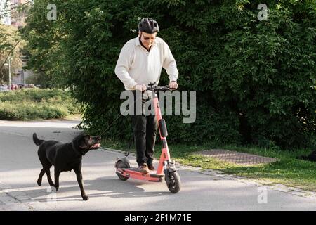 Homme senior en scooter électrique dans le parc Banque D'Images