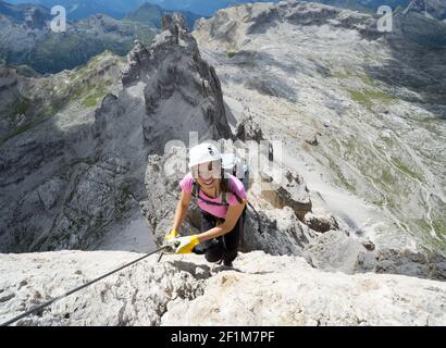 Belle femme brunette grimpeur sur une voie raide et exposée Ferrata dans les Dolomites Banque D'Images