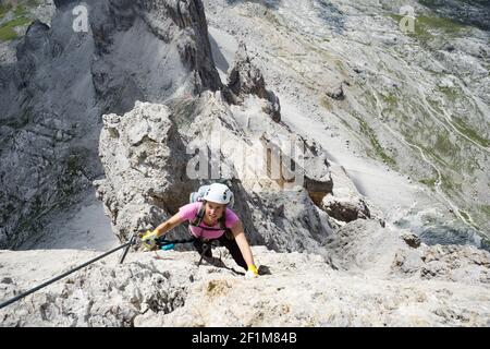Belle femme brunette grimpeur sur une voie raide et exposée Ferrata dans les Dolomites Banque D'Images