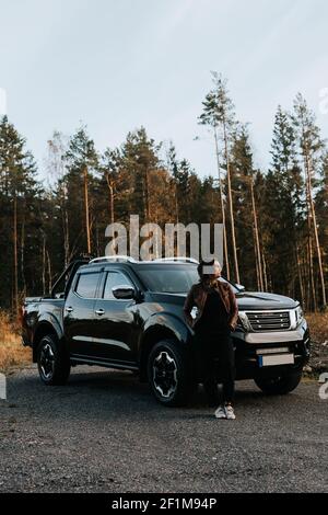 Femme debout devant la voiture Banque D'Images