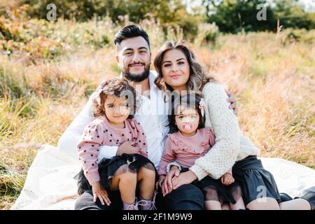 Parents avec deux filles regardant l'appareil photo Banque D'Images