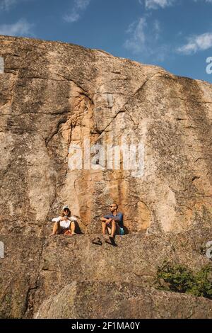 Vue à angle bas d'un couple assis sur un rocher Banque D'Images