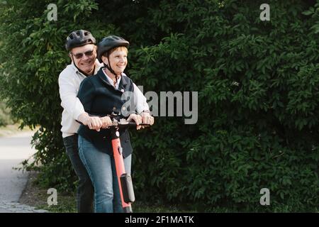 Couple senior sur scooter électrique Banque D'Images