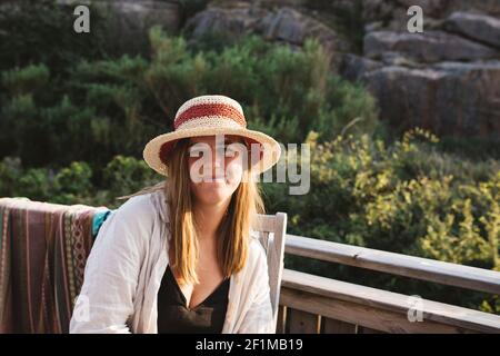 Femme souriante portant un chapeau de soleil regardant l'appareil photo Banque D'Images