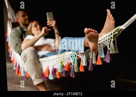 Gros plan sur les pieds des femmes tout en étant allongé sur un hamac Banque D'Images