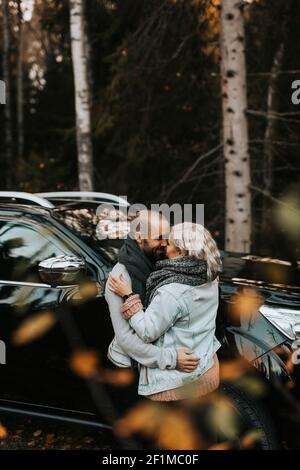 Couple qui se serre devant la voiture Banque D'Images