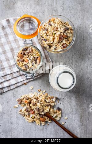 Petit déjeuner céréales dans un bol et lait dans une bouteille. Muesli sain avec flocons d'avoine, noix et raisins secs. Vue de dessus. Banque D'Images