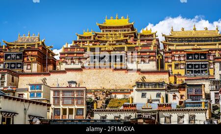 Monastère bouddhiste tibétaine de Songzanlin en gros plan, vue pittoresque et colorée sur la façade avec toits d'or sur ciel bleu clair à Shangri-la Yunnan Chine Banque D'Images