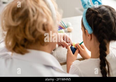 Concept de Pâques. La grand-mère avec sa petite-fille tient des œufs de Pâques à la maison Banque D'Images