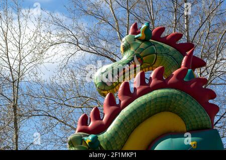 la tête d'un dragon gonflable face aux arbres de bouleau et ciel bleu Banque D'Images