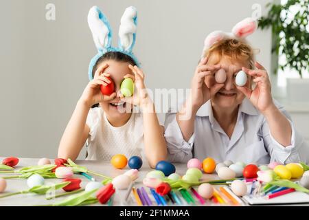 Concept de Pâques. La grand-mère avec sa petite-fille tient des œufs de Pâques à la maison Banque D'Images