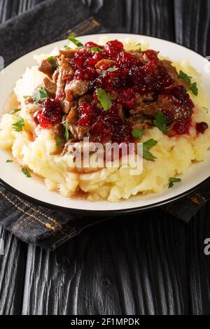 Poronkaristys Sauteed Reinner, purée de pommes de terre et baies de lingonis dans une assiette sur la table. Verticale Banque D'Images