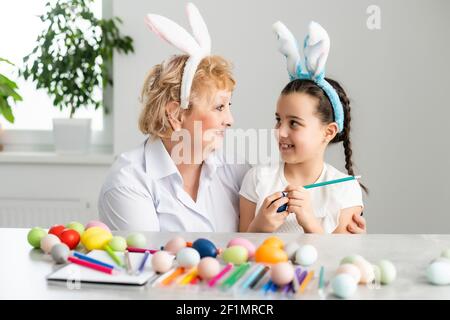 Concept de Pâques. La grand-mère avec sa petite-fille tient des œufs de Pâques à la maison Banque D'Images