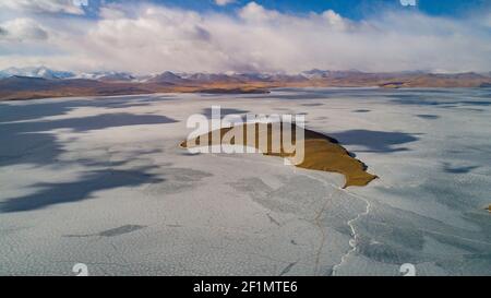 (210309) -- LHASSA, 9 mars 2021 (Xinhua) -- photo aérienne prise le 6 mars 2021 montre une île sur le lac gelé Puma Yumco, dans le sud-ouest de la Chine, région autonome du Tibet. Chaque année, au plus froid, au village de Dowa, à 5,070 mètres au-dessus du niveau de la mer, des milliers de moutons traversent l'eau gelée jusqu'aux îles du lac Puma Yumco, l'un des plus hauts lacs du monde. Les bergers passent généralement un mois avec les animaux sur les îles, où l'herbe pousse à la taille. Lorsque le printemps approche, les troupeaux de moutons seront ramenés à leur ancien habitat, en traversant à nouveau le lac gelé avant le Banque D'Images