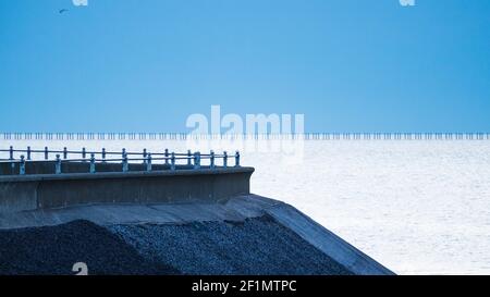 Résumé image du mur de mer au Gunners Park, dans le Shoeburyness, avec le boom de la défense de l'ancienne Guerre froide en arrière-plan. Couleurs bleues, avant l'aube Banque D'Images