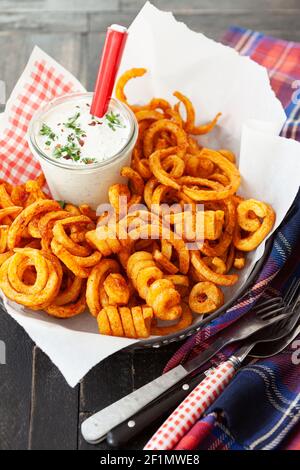 Frites bouclés, frites torsadées avec sauce Banque D'Images