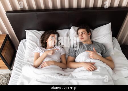 Vue de dessus des têtes de couple heureux et charmant couché lit Banque D'Images