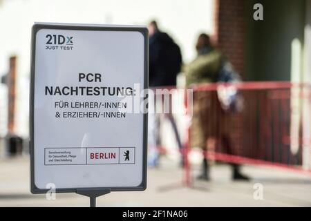 Berlin, Allemagne. 09e mars 2021. Les gens font la queue devant le Corona Rapid Test Center sur Lehrter Straße derrière un panneau indiquant « PCR Retesting for Teachers and Educators ». Depuis 08.03.2021, Berliners peut être testé gratuitement une fois par semaine pour le virus corona. Credit: Kira Hofmann/dpa-Zentralbild/dpa/Alay Live News Banque D'Images