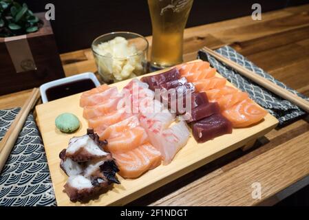 Vue rapprochée d'une délicieuse assiette de sashimi frais dans un bar à sushis Banque D'Images