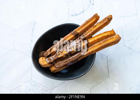 Bâtonnets de churros avec sauce au chocolat . Pâte frite pâtisserie traditionnelle espagnole ou mexicaine dessert. Prêt à servir et à manger. Banque D'Images