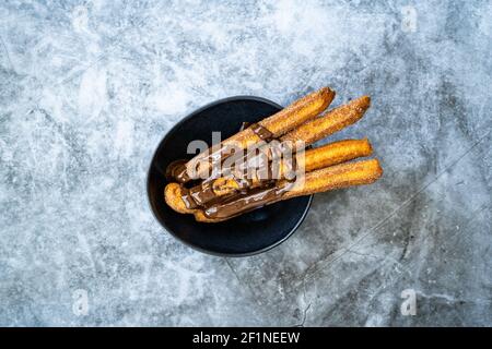 Bâtonnets de churros avec sauce au chocolat . Pâte frite pâtisserie traditionnelle espagnole ou mexicaine dessert. Prêt à servir et à manger. Banque D'Images