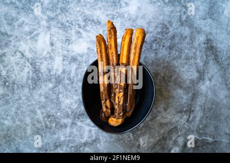 Bâtonnets de churros avec sauce au chocolat . Pâte frite pâtisserie traditionnelle espagnole ou mexicaine dessert. Prêt à servir et à manger. Banque D'Images