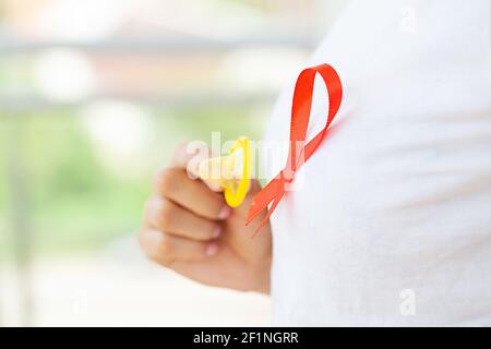 Femme d'affaires attirante avec ruban rouge et condom montrant dans les mains Banque D'Images