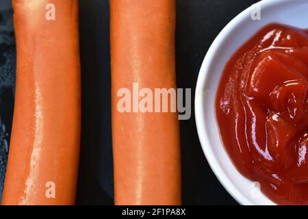 tranche de saucisse de porc frite trempée avec ketchup sur l'assiette Banque D'Images