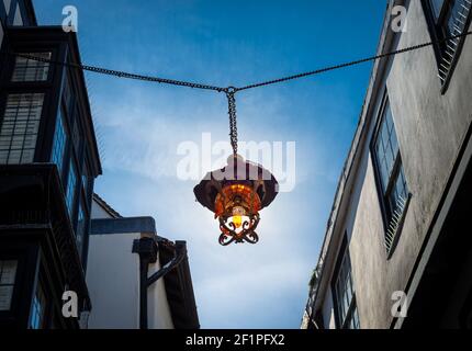 Une lanterne décorative est suspendue entre les bâtiments de Mercery Lane, dans la ville historique de Canterbury, en Angleterre. Banque D'Images