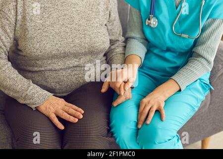 Gros plan du médecin tenant la main de la patiente senior, la soutenant et la réconfortant Banque D'Images
