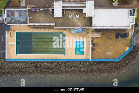 Gourock, Écosse, Royaume-Uni. 9 mars 2021. Le verrouillage du coronavirus a fait que la piscine extérieure de Gourock a été fermée au public pendant des mois et l'eau de la piscine est devenue stagnante et sale. Beaucoup d'entretien et de nettoyage seront nécessaires pour amener la piscine à l'état de préparation quand le verrouillage est détendu. Photo : vue aérienne sur la piscine. Iain Masterton/Alay Live News Banque D'Images