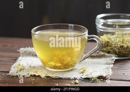 Tisane florale Meadowsuet dans une tasse de verre avec herbes séchées dans un pot à proximité sur la table rustique en bois, gros plan, espace de copie, médecine naturelle et de la guérist Banque D'Images