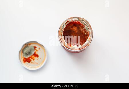 Une conserve de pâte de tomate gâtée avec un moule vert et blanc à l'intérieur, photo du dessus. Ketchup pourri Banque D'Images
