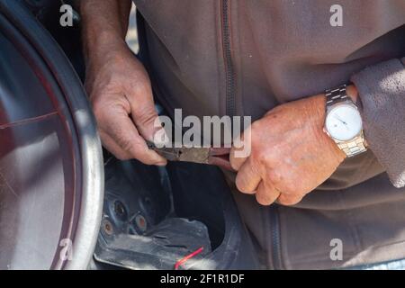 Mécanicien répare un rétro-éclairage de voiture dans un garage Banque D'Images