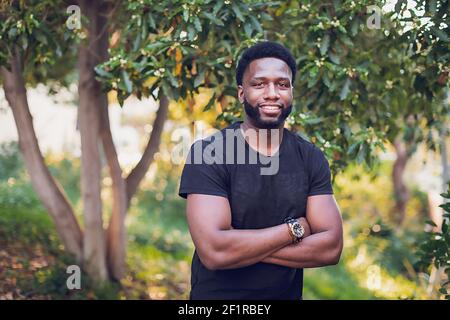 Tête d'un jeune homme noir avec les bras croisés. Banque D'Images