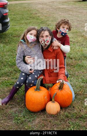 Une mère et ses enfants cueillant des citrouilles dans une ferme de l'Illinois. Banque D'Images