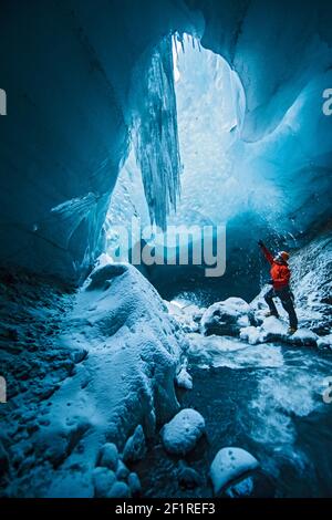 Homme explorant la grotte de glace à Thórsmörk - Islande Banque D'Images