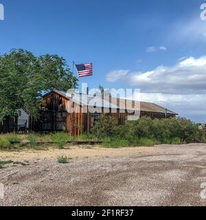 Vieux ranch en bois avec drapeau américain dans le désert Banque D'Images