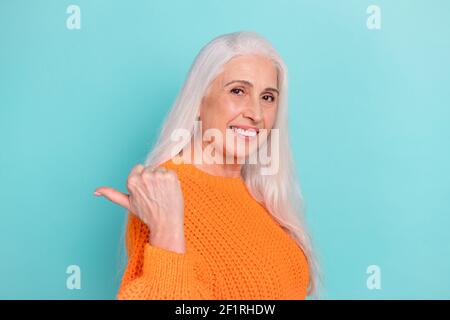 Profil vue latérale portrait d'une jolie femme gaie aux cheveux gris montrant espace de copie idea isolé sur fond bleu sarcelle de couleur vive Banque D'Images
