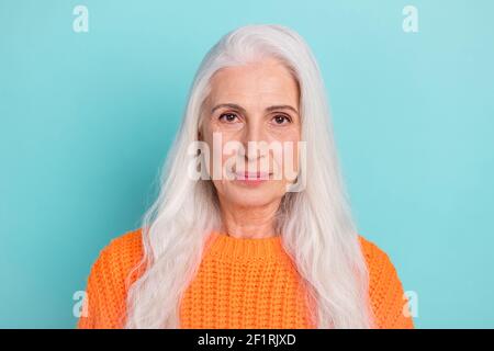 Portrait en gros plan de contenu attrayant femme à cheveux longs portant un pull isolé sur fond bleu sarcelle de couleur vive Banque D'Images